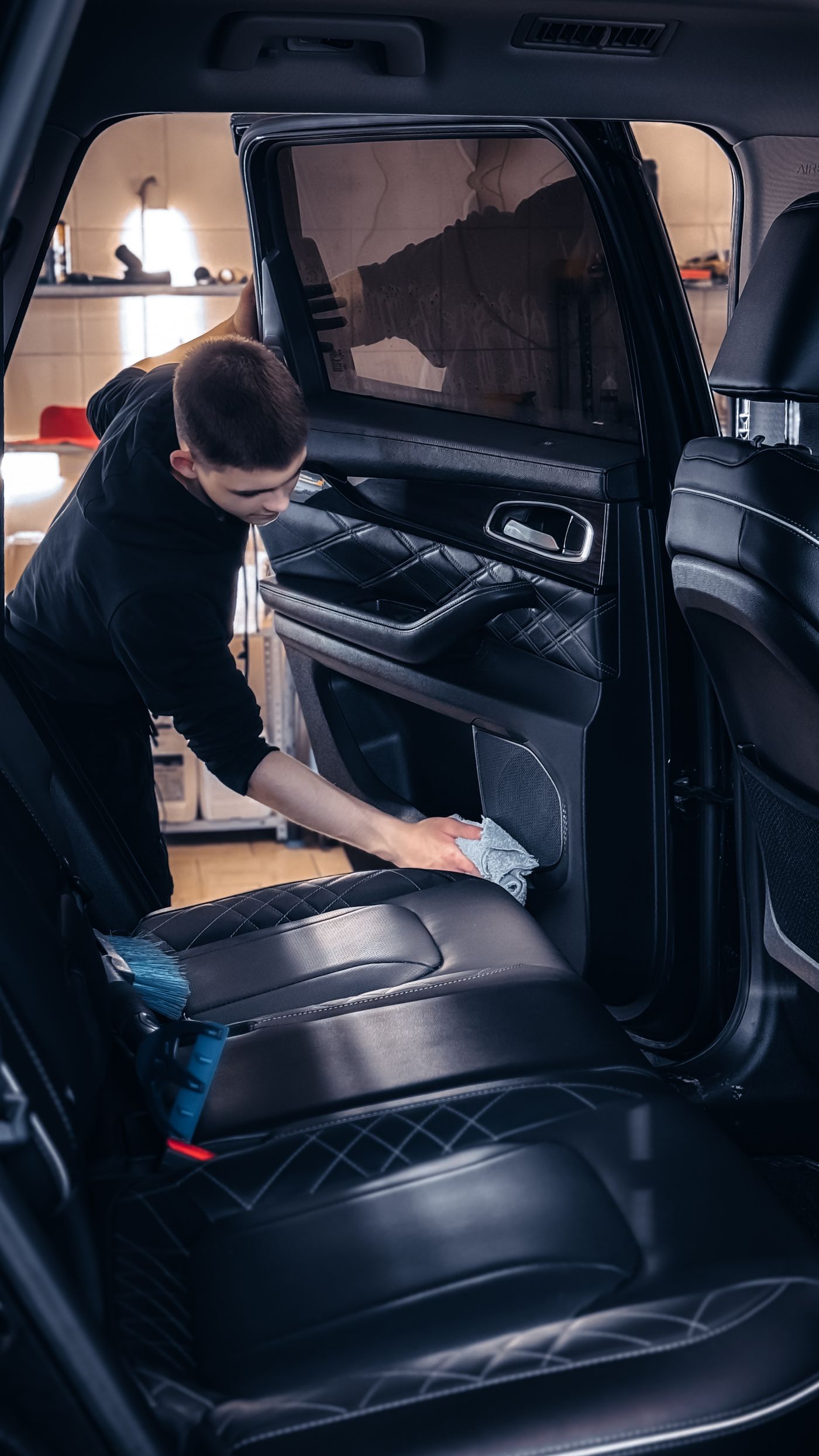 Мастер очищает кожаный салон автомобиля